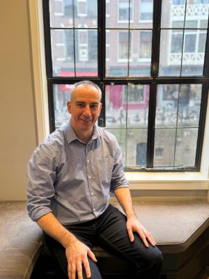 Foto van Willem van den Berg op een bankje aan de Oudegracht in Utrecht